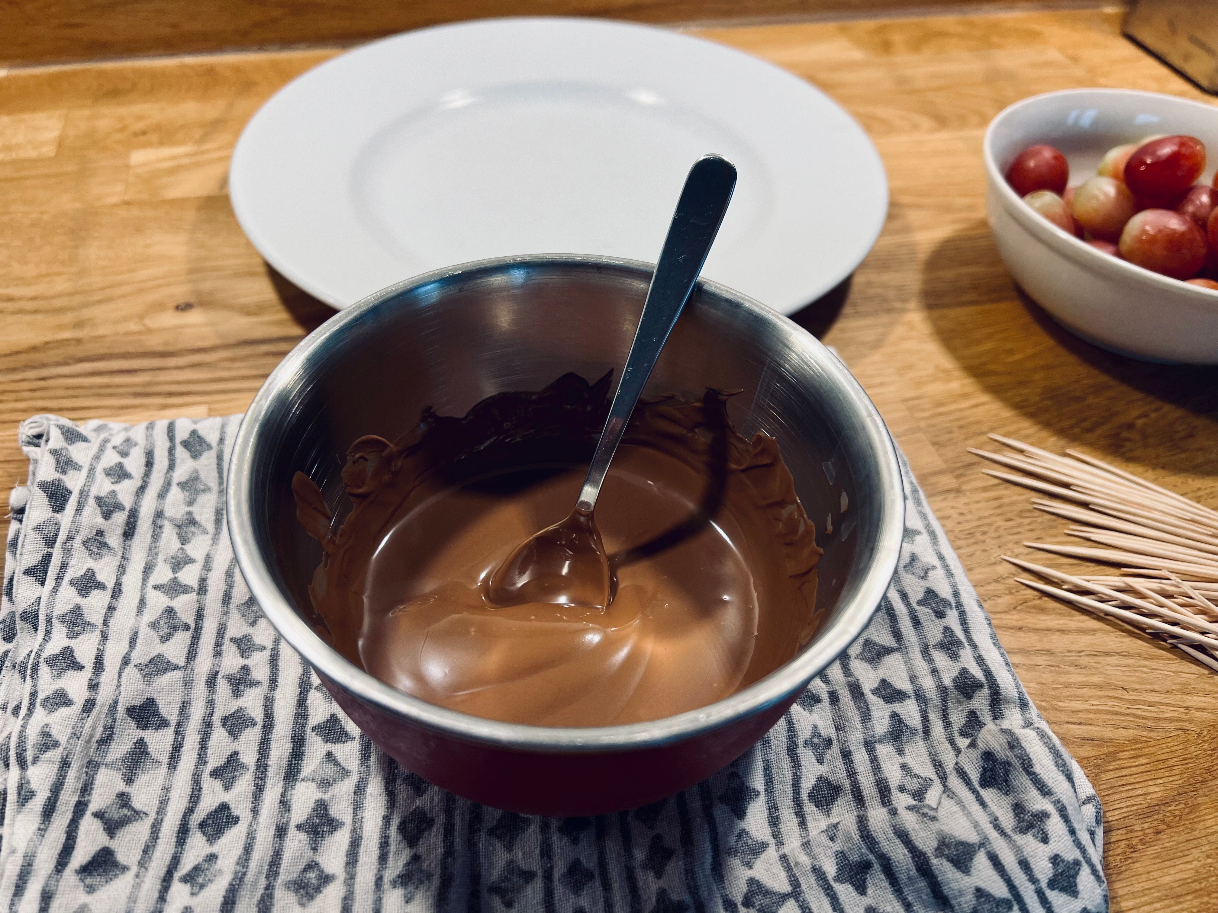 Schüssel mit geschmolzener veganer Schokolade und einem Löffel darin